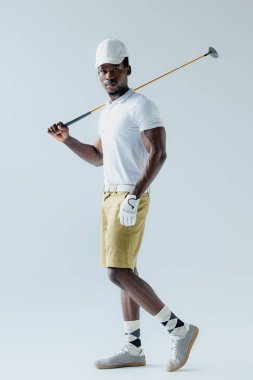 emin Afrikalı Amerikan golf oyuncusu gri arka planda kamera bakıyor