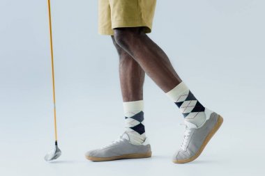 gri arka planda African American sporcu Holding Golf Kulübü kırpılmış görünümü