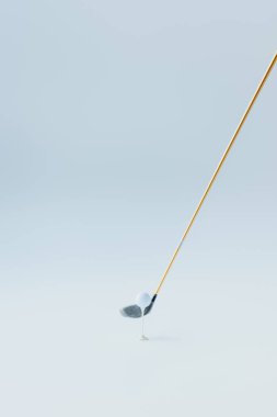 golf club near golf ball on tee on grey background clipart