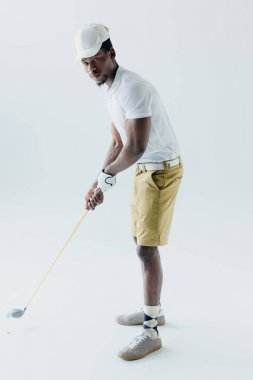 gri arka planda yakışıklı Afrikalı Amerikan sporcu Golf oynuyor