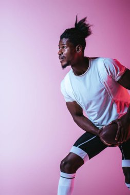 degrade ile mor arka planda Amerikan futbolu oynayan yakışıklı Afrikalı Amerikan sporcu