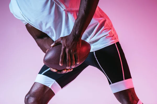 그라데이션과 보라색 배경에 축구를 아프리카 미국인 스포츠맨의 부분보기 — 스톡 사진