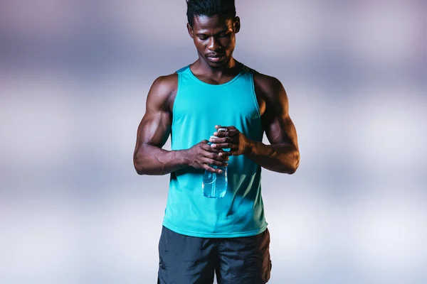 Serious African American Sportsman Holding Sports Bottle Grey Background Lighting — Stock Photo, Image