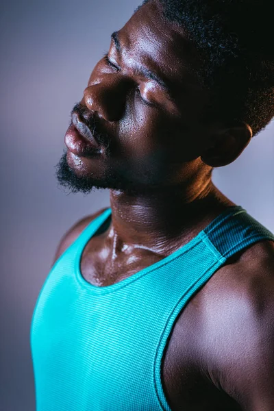 汗をかいた顔と照明付き灰色の背景に目を閉じたアフリカ系アメリカ人スポーツマンの肖像画 — ストック写真