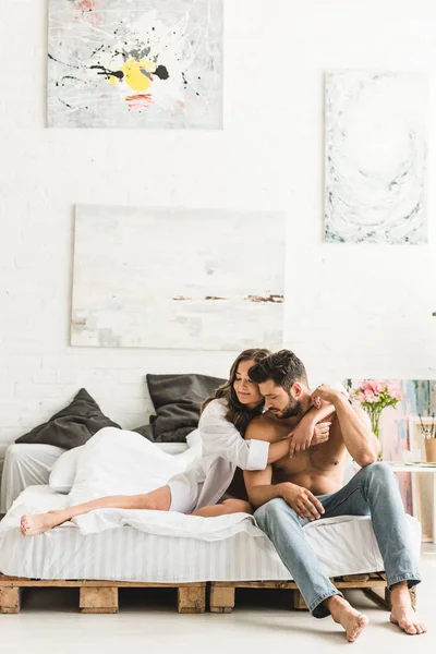 两个相爱的人坐在床上 闭着眼睛拥抱 — 图库照片