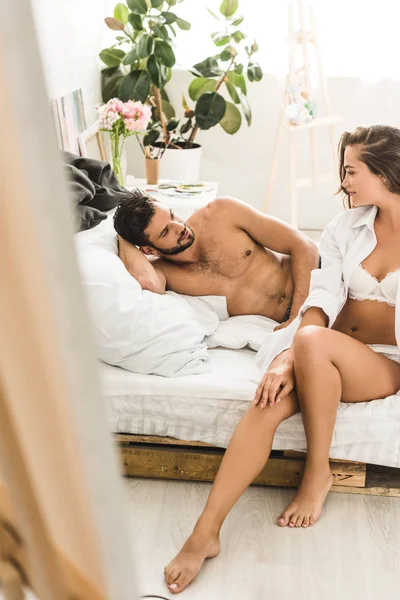 Selektywne Skupienie Sexy Para Siedzi Sypialni Uśmiechając Się Patrząc Siebie — Zdjęcie stockowe