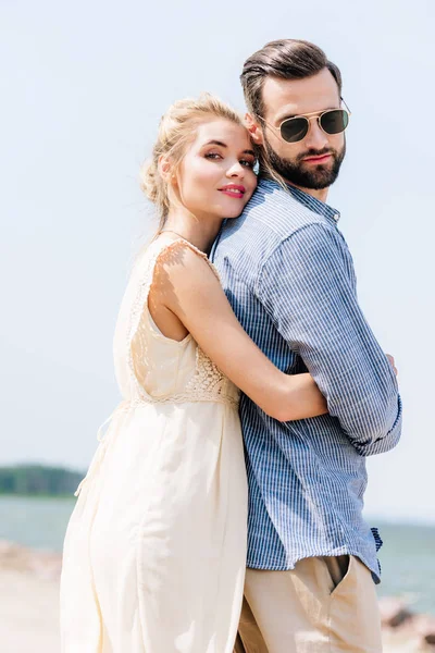 ビーチであごひげのボーイフレンドを抱きしめる幸せなブロンドの女性の低角度のビュー — ストック写真