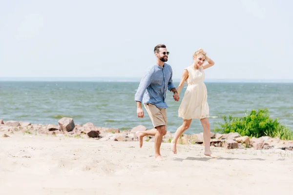 Smiling Young Couple Holding Hands While Running Beach — Stock Photo, Image