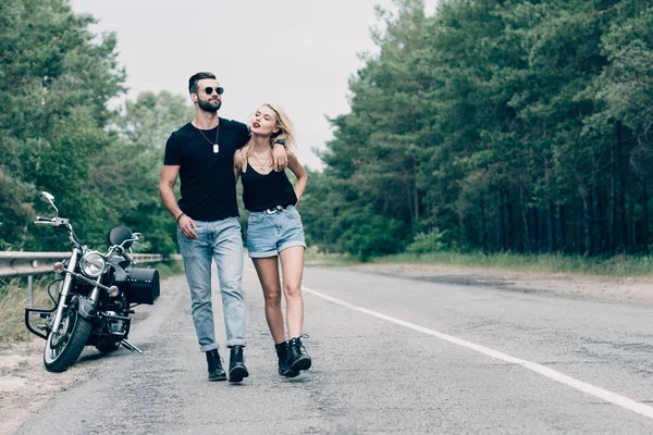 Joven Pareja Ciclistas Caminando Por Carretera Cerca Negro Motocicleta Bosque — Foto de Stock