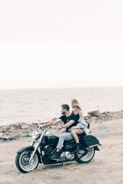 nehir yakınında siyah motosiklet üzerinde bisikletçileri genç çift