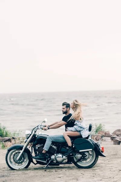 Vista Lateral Jovem Casal Motociclistas Andando Moto Preta Praia Areia — Fotografia de Stock