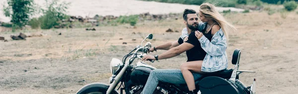 Young Couple Bikers Hugging Black Motorcycle Sandy Beach River Panoramic — Stock Photo, Image