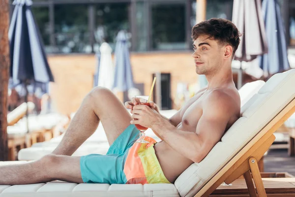 Jovem Sorridente Olhando Para Longe Enquanto Descansava Cadeira Praia Com — Fotografia de Stock