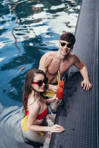 ferahlatıcı içecek bardak clinking ve kamera gülümseyen mutlu genç çift