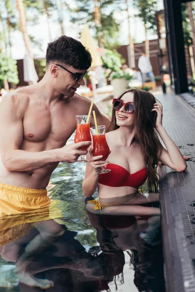 Feliz Casal Jovem Clinking Copos Com Bebida Refrescante Enquanto Relaxa — Fotografia de Stock