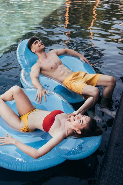 Cheerful Young Couple Relaxing Swim Rings Pool Looking — Stock Photo, Image