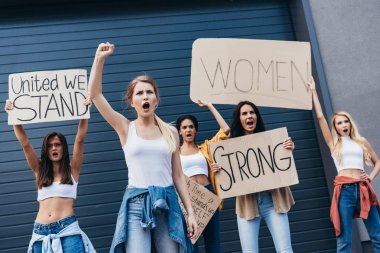 beş çok ırklı feministler sloganlar ve sokakta çığlık ile pankartlar tutan