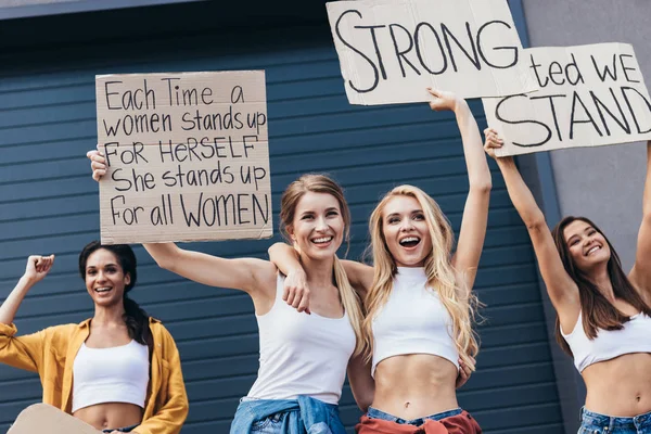 Vier Glimlachende Multi Etnische Feministen Omarmen Houden Borden Met Slogans — Stockfoto