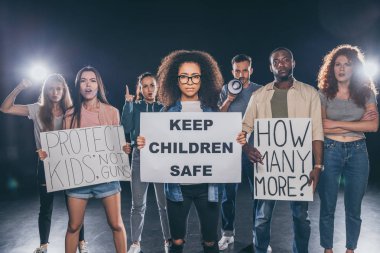 siyah insanların bir grup yakınında çocuklar güvenli harflertutmak ile pankart tutan afrikalı amerikalı kadın 