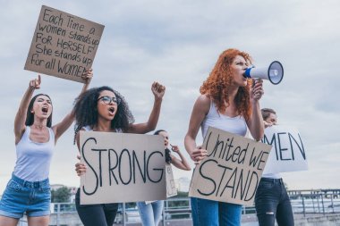 multicultural girls holding placards and screaming outside  clipart