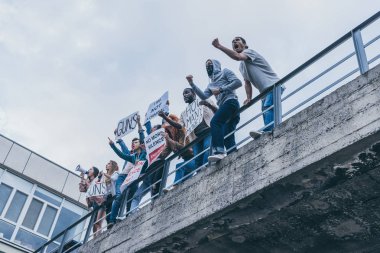 pankart tutarken çığlık ve gesturing çok kültürlü insanların düşük açı görünümü 