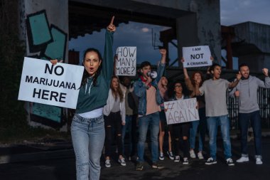 çığlık çok kültürlü insanların yakınında hiçbir marihuana yazı ile pankart tutan kadının seçici odak 