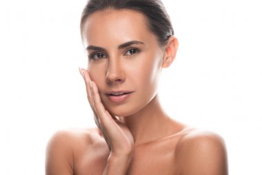 ilgilenen çıplak genç kadın el ile yüze dokunmave beyaz izole kamera bakıyor