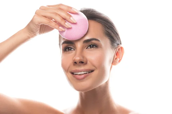 Sorrindo Jovem Mulher Usando Escova Limpeza Facial Olhando Para Longe — Fotografia de Stock