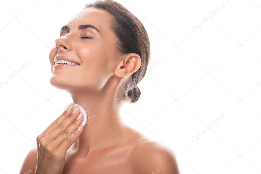 nude young woman using cotton pad with closed eyes and laughing isolated on white