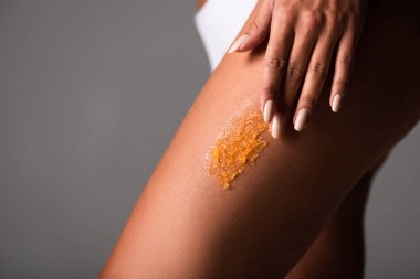 gri izole vücut scrub uygulayan seksi genç kadın kısmi görünümü