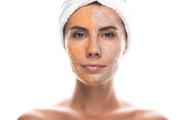 front view of young woman in cosmetic hair band with scrub on face isolated on white