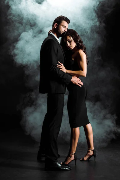 Όμορφος Μουσάτος Άντρας Στέκεται Και Αγκαλιάζει Γυναίκα Φόρεμα Μαύρο Καπνό — Φωτογραφία Αρχείου