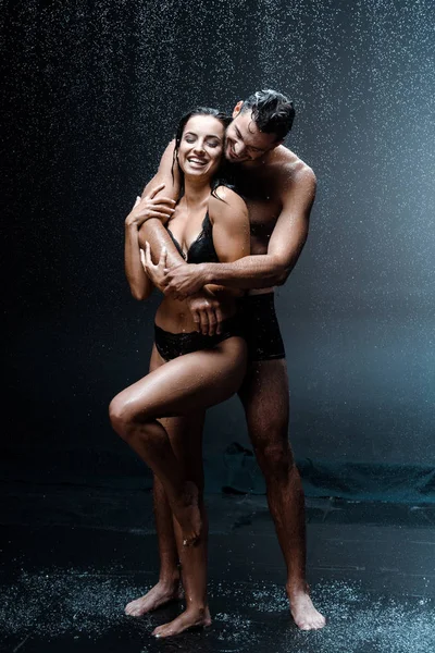 Happy Shirtless Man Hugging Cheerful Wet Woman Raindrops Black — Stock Photo, Image