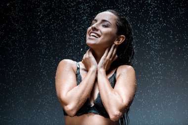 siyah yağmur damlaları altında duran dantel sütyen mutlu ve seksi kadın  