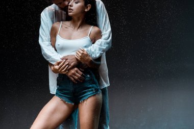 siyah yağmur damlaları altında seksi ıslak kız arkadaşı sarılma adam kırpılmış görünümü 
