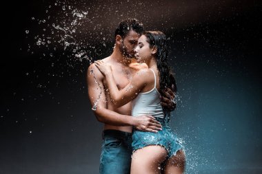 gömleksiz ve seksi adam siyah su sıçraması yakın denim şort kız arkadaşı sarılma 