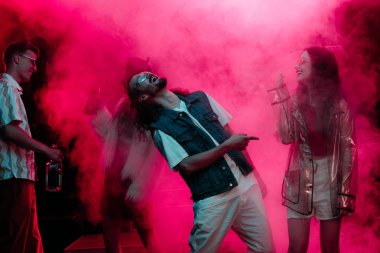erkek ve kızlar pembe duman ile gece kulübünde dans