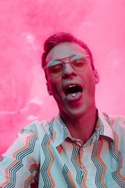 man with lsd on tongue in nightclub with pink smoke clipart