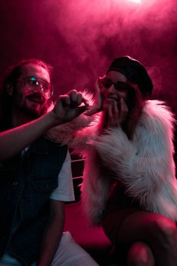 gece kulübünde gülümseyen kıza marihuana ortak veren adam