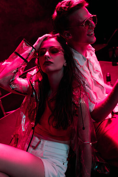 man and young woman  sunglasses during rave party in nightclub