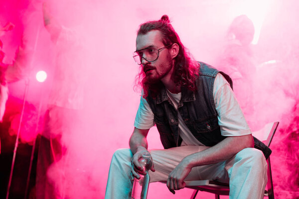 sick man sitting with bottle of water in nightclub