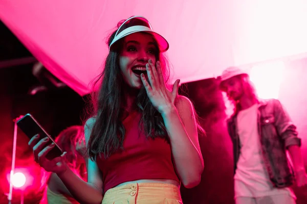 Menina Surpreso Com Smartphone Cobrindo Boca Durante Festa Rave Boate — Fotografia de Stock