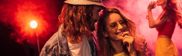 panoramic shot of man and beautiful happy young woman during rave party in nightclub