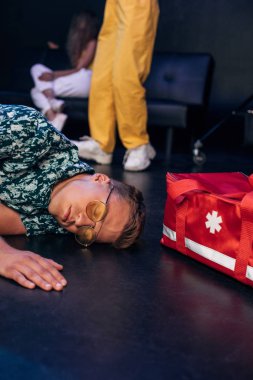 gece kulübünde ilk yardım çantası yakınında yerde yatan güneş gözlüğü hasta adam