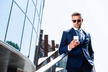 akıllı telefon kullanarak cebinde el ile takım elbise yakışıklı adam 