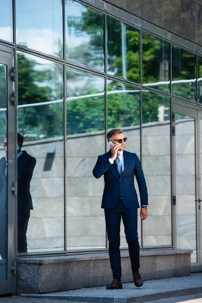 Stilig Man Kostym Och Glasögon Pratar Smartphone — Stockfoto