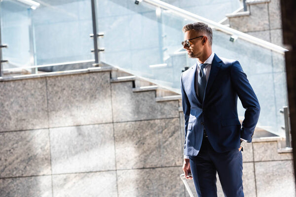 Красивый мужчина в костюме и в очках с карманными глазами
 