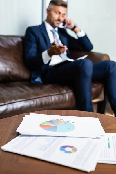 Selective Focus Papers Table Man Talking Smartphone Background — Stock Photo, Image