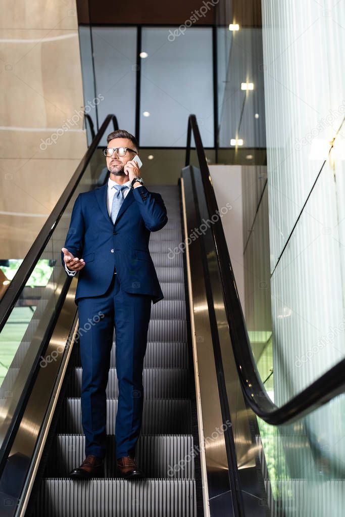 handsome businessman in suit and glasses talking on smartphone 