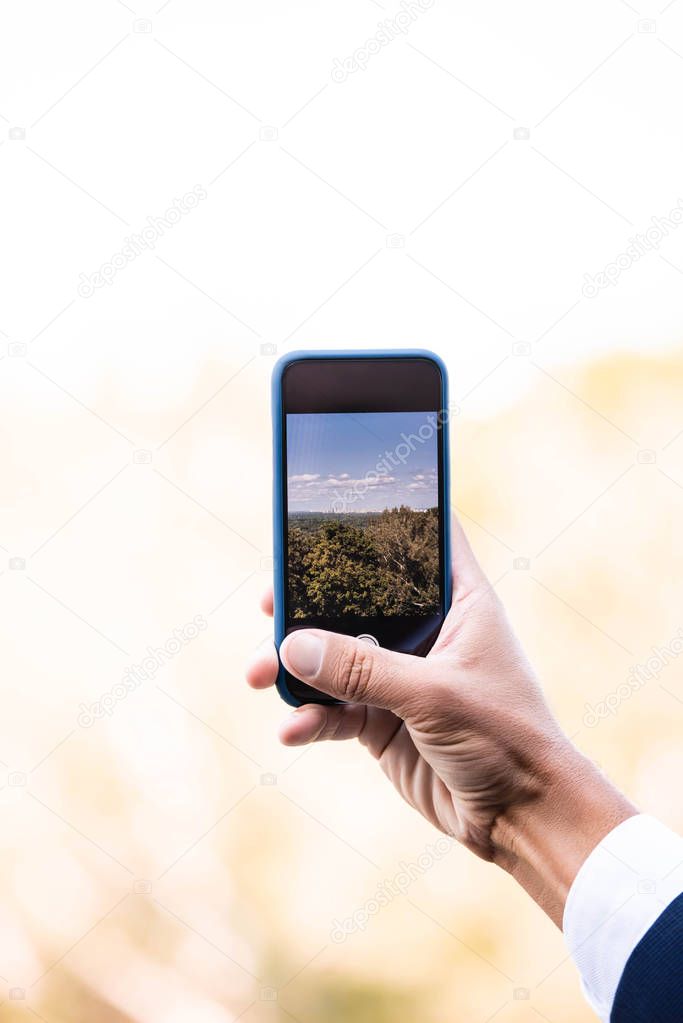 cropped view of man talking selfie of city with smartphone 